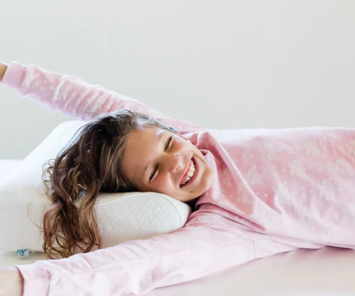 Toddler girl sleeping on her back with the Posture Form toddler pillow