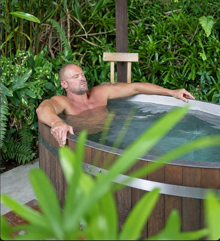 Andrew in a cold plunge barrel in the garden